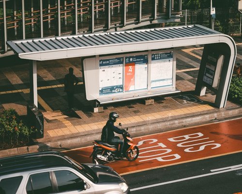 Person shifting weight while standing at a bus stop in Jakarta